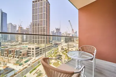 a balcony with chairs and a view of a city at FAM Living Dubai Escape Sleek Studio at Peninsula Five in Dubai