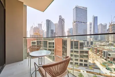 a balcony with a table and chairs and a city view at FAM Living Dubai Escape Sleek Studio at Peninsula Five in Dubai