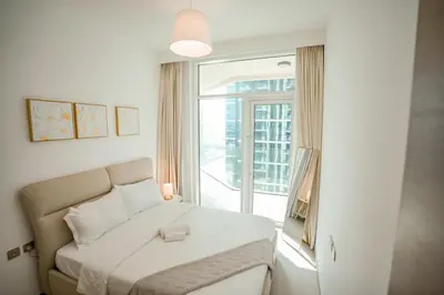 a bedroom with a bed and a large window at 2-Bed Apartment with Infinity Pool in Dubai