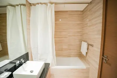 a bathroom with a white tub and a sink at 2-Bed Apartment with Infinity Pool in Dubai