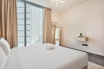 a white bed in a room with a window at STAY BY LATINEM Luxury 2BR Plus Study Holiday Home CB 3312 Near Burj Khalifa in Dubai