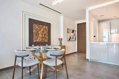 a dining room with a glass table and chairs at STAY BY LATINEM Luxury 2BR Plus Study Holiday Home CB 3312 Near Burj Khalifa in Dubai