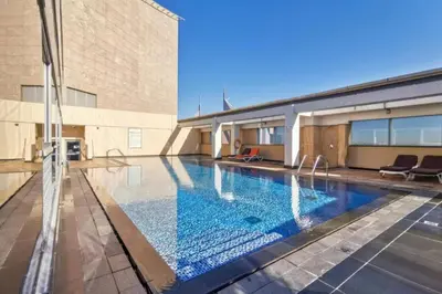 a swimming pool in front of a building at Sky Gardens - High Rise Studio with Cityscape View in Dubai