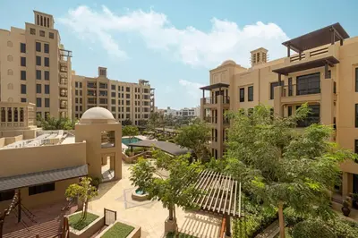 an apartment complex with a courtyard with trees and buildings at StayMada - Lamtara Near Burj AlArab Beach Access in Dubai