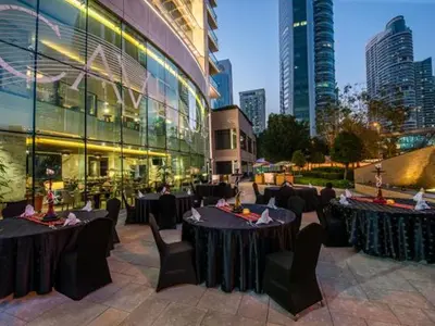 a restaurant with tables and chairs in front of a building at Cosmos Living Majestic Studio GCV2 in Dubai
