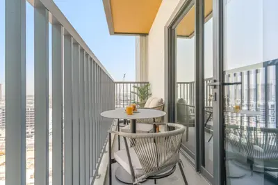 a balcony with a table and chairs on a building at VayK - Modern 2BR with Pool View in Sobha Hartland in Dubai