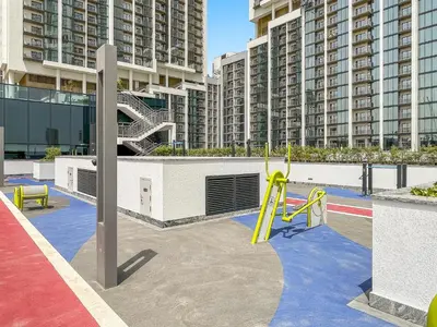 a playground with a slide and some buildings at VayK - Modern 2BR with Pool View in Sobha Hartland in Dubai