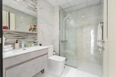 a bathroom with a shower and a toilet and a sink at Vogue Al Furjan Pearlz by Danube near Ibn Battuta Mall, Three Bedroom plus Kids room Apartment with Balcony and Private pool, Access to all Amenities, Walkable to Al Furjan Metro Station in Dubai