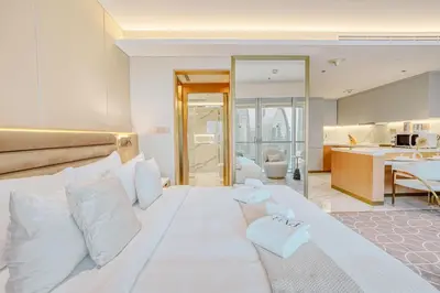 a bedroom with a large white bed with white pillows at PVH - Burj Khalifa View Studio - Emaar Residence Fashion Avenue in Dubai