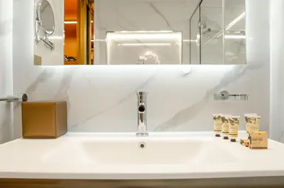 a bathroom with a white sink and a mirror at PVH - Burj Khalifa View Studio - Emaar Residence Fashion Avenue in Dubai