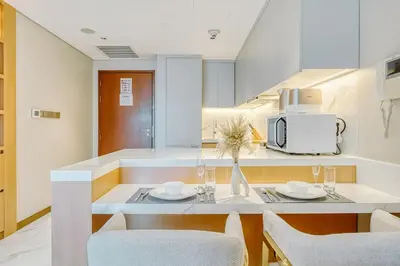 a kitchen with a table and chairs and a microwave at PVH - Burj Khalifa View Studio - Emaar Residence Fashion Avenue in Dubai