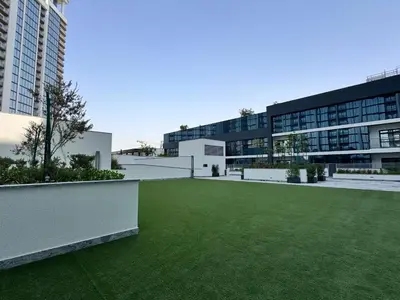 a large building with a green lawn in front of it at Luxury 2BR in Sobha Hartland in Dubai