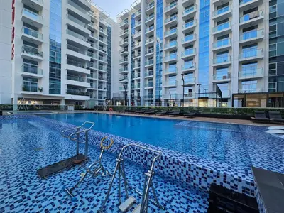 a large swimming pool with two large buildings at Vogue Al Furjan Pearlz by Danube near Ibn Battuta Mall, One Bedroom Apartment with Balcony and Pool View, Access to all Amenities, Walkable to Al Furjan Metro Station in Dubai