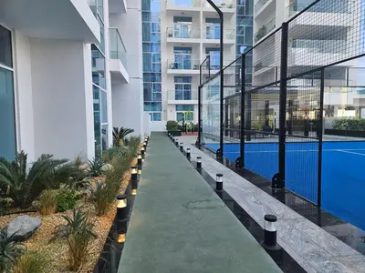 a walkway in a building with a swimming pool at Vogue Al Furjan Pearlz by Danube near Ibn Battuta Mall, One Bedroom Apartment with Balcony and Pool View, Access to all Amenities, Walkable to Al Furjan Metro Station in Dubai