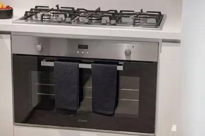 a stove with two towels hanging from the oven at Premium Suite 3 BR 200 degree Views 85-inch TV and Sunset View in Dubai