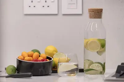 a bowl of fruit and a bottle of lemonade and a bowl of lemons at Premium Suite 3 BR 200 degree Views 85-inch TV and Sunset View in Dubai