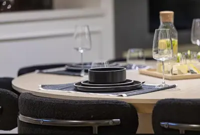 a table with two wine glasses and a black hat on it at Premium Suite 3 BR 200 degree Views 85-inch TV and Sunset View in Dubai