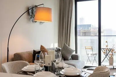 a living room with a couch and a table with glasses at TRPS - Alef Noon, JVC - Brand New - Luxury Furnished 1BR - Prime JVC Location in Dubai