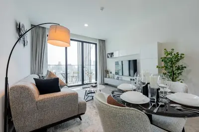 a living room with a table and chairs and a couch at TRPS - Alef Noon, JVC - Brand New - Luxury Furnished 1BR - Prime JVC Location in Dubai
