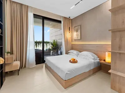 a hotel room with a bed and a balcony at BLVD - Stylish Stay with Private Jacuzzi and Canal View in Dubai