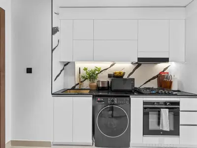a kitchen with a stove and a dishwasher at BLVD - Stylish Stay with Private Jacuzzi and Canal View in Dubai