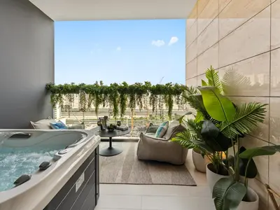 a bathroom with a tub and a patio with plants at BLVD - Stylish Stay with Private Jacuzzi and Canal View in Dubai