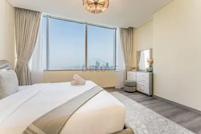 a bedroom with a large white bed and large windows at Close to Museum of the Future with Zaabeel Palace Views, Minutes from Dubai Mall And Burj Khalifa - Sky Gardens, DIFC by Deluxe Holiday Homes in Dubai
