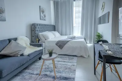 a living room with a bed and a couch at Studio JVC I Fully Furnished I Epic Pool in Dubai