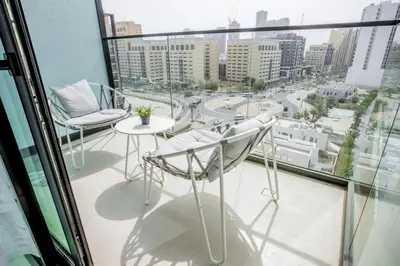 a balcony with two chairs and a table at Studio JVC I Fully Furnished I Epic Pool in Dubai
