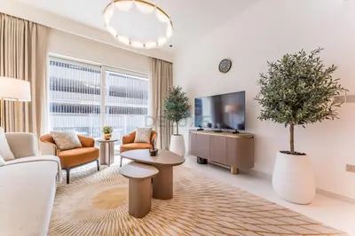 a living room with a couch and a tv at Partial Sea Views with Private Beach Access, Near Dubai Marina and Palm Jumeirah, Grand Bleu Tower by Elie Saab, Tower 2, Emaar Beachfront by Deluxe Holiday Homes in Dubai
