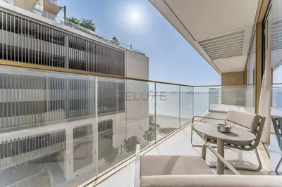 a balcony with a table and a view of the ocean at Partial Sea Views with Private Beach Access, Near Dubai Marina and Palm Jumeirah, Grand Bleu Tower by Elie Saab, Tower 2, Emaar Beachfront by Deluxe Holiday Homes in Dubai