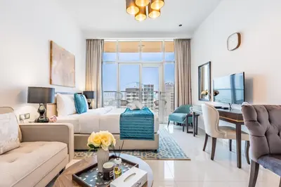 a living room with a couch and a table at Studio Overlooking the Pool, Close to Parks, Grocery Stores, and Circle Mall, Damac Ghalia, JVC by Deluxe Holiday Homes in Dubai
