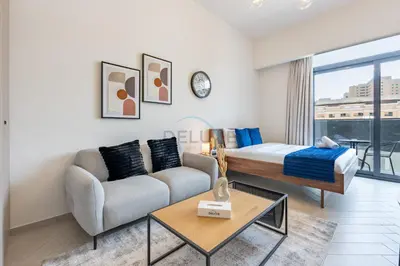 a living room with a couch and a bed at Cozy Studio with Peaceful Community Views, Just Steps from Parks and Circle Mall, Oxford 212, JVC by Deluxe Holiday Homes in Dubai