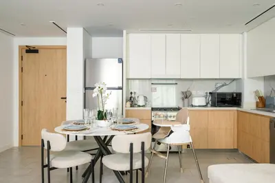 a kitchen and dining room with a table and chairs at Beach Please in Dubai