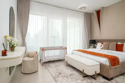 a hotel room with a large bed and a chair at Beach Please in Dubai