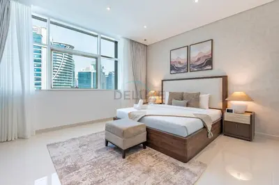 a bedroom with a bed and a large window at Walking Distance to Bay Avenue Mall, 5 Minutes Drive to Downtown Dubai, Close to Metro Station, With Canal View, The Cosmopolitan, Business Bay by Deluxe Holiday Homes in Dubai