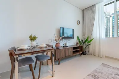 a dining room with a wooden table and chairs at Walking Distance to Bay Avenue Mall, 5 Minutes Drive to Downtown Dubai, Close to Metro Station, With Canal View, The Cosmopolitan, Business Bay by Deluxe Holiday Homes in Dubai