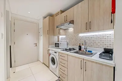 a kitchen with a sink and a washing machine at Seven Palm Studio Roof Top Pool Beach Gym for free in Dubai