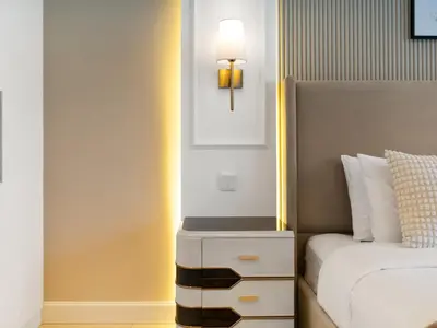 a bedroom with a bed and a nightstand next to a bed at Kensington Perfect 1BR Burj View and Dubai Mall Link in Dubai