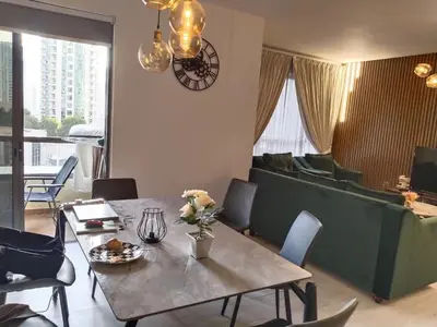 a living room with a table and a couch at Expedite Homes in Dubai