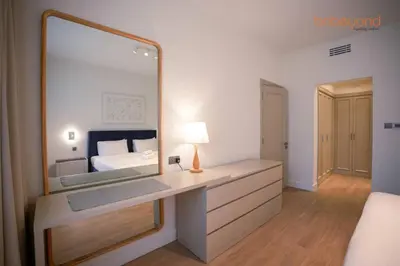 a bedroom with a large mirror and a bed at Bnbeyond Ultra-Luxe 2BR with Burj Khalifa Panorama in Dubai