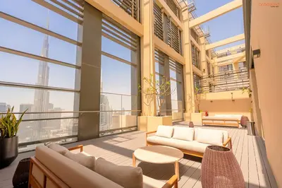 a balcony with couches and tables in a building at Burj Khalifa Light Show from your Bed in Dubai