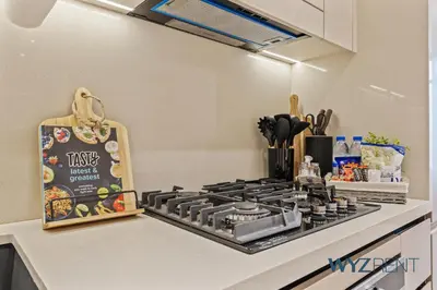 a kitchen with a stove top oven next to a counter at Boho Grecian Studio in JVC Pool & Gym Access in Dubai