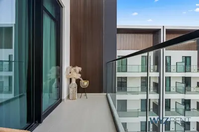 a balcony with a vase of flowers on a building at Boho Grecian Studio in JVC Pool & Gym Access in Dubai