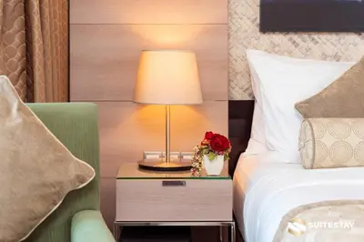 a hotel room with a bed and a table with a lamp at Dubai Mall Apartments by Suitestay in Dubai
