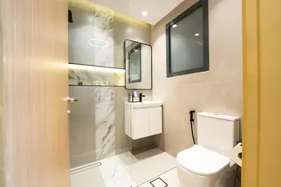 a bathroom with a toilet and a sink and a mirror at Luxury Studio JVC Open View in Dubai