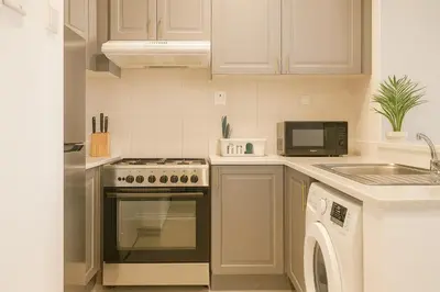 a kitchen with a stove and a sink and a microwave at 1 Bhk Huge Apartment In Heart of Dubai Marina in Dubai
