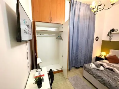 a small room with a bed and a television at Budget Friendly Partition in Barsha Heights Near Metro in Sabkhah