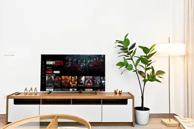 a living room with a tv on a white wall at Modern 3BD with Maid's Room near Lagoon at Lotus 4 in Dubai