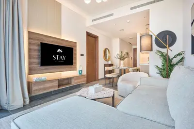 a living room with a couch and a tv at STAY BY LATINEM Luxury 1BR Holiday Home CC 0821 Near Downtown in Dubai